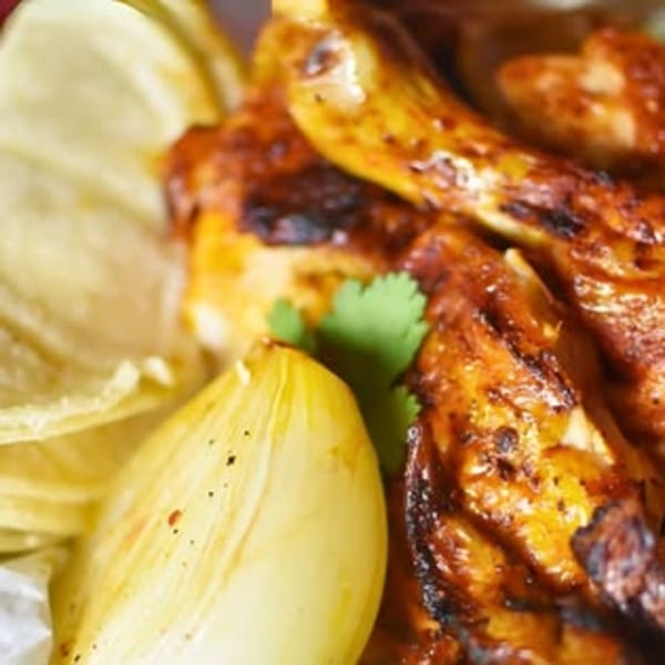 Close-up of Rey del Pollo's grilled chicken with cilantro, onions, and tortilla chips.